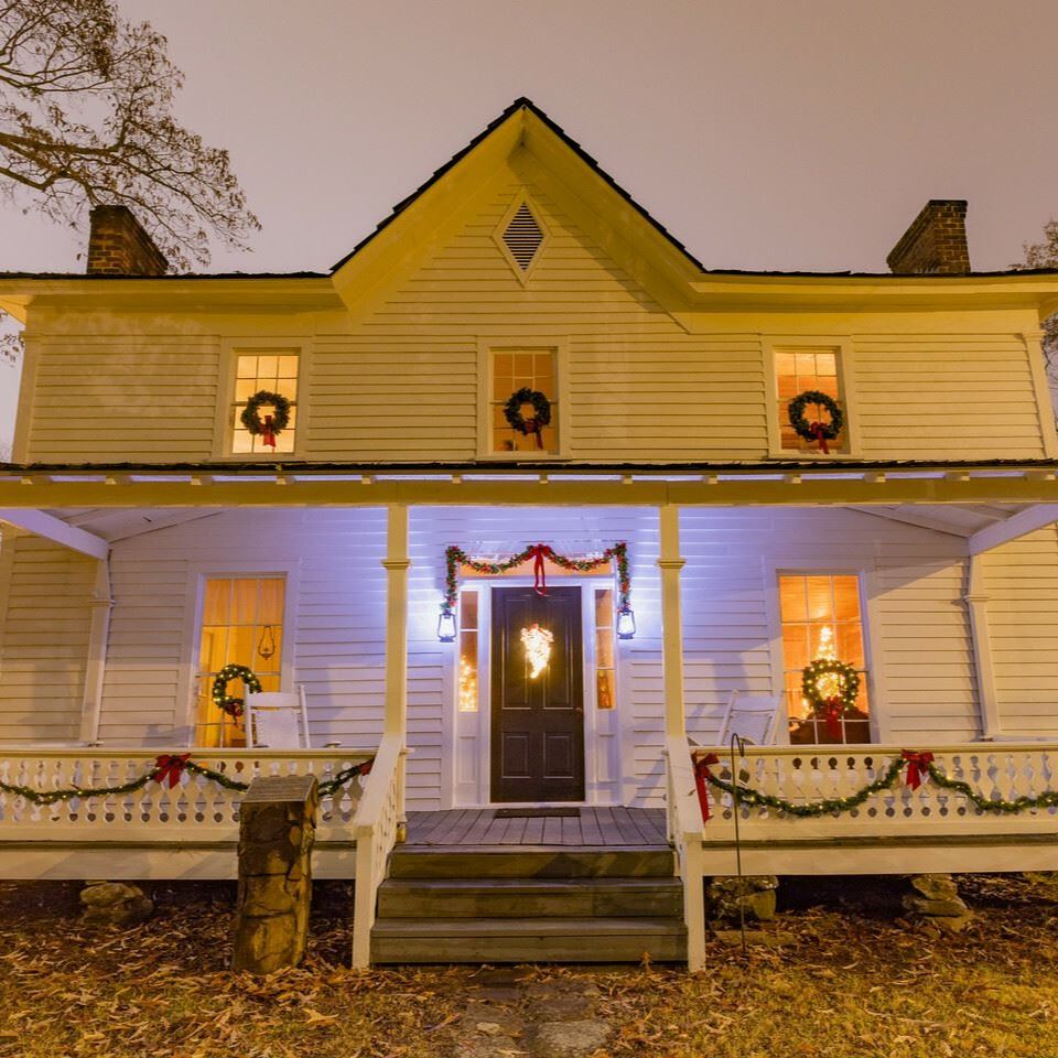 historic white house with porch and christmas wreaths