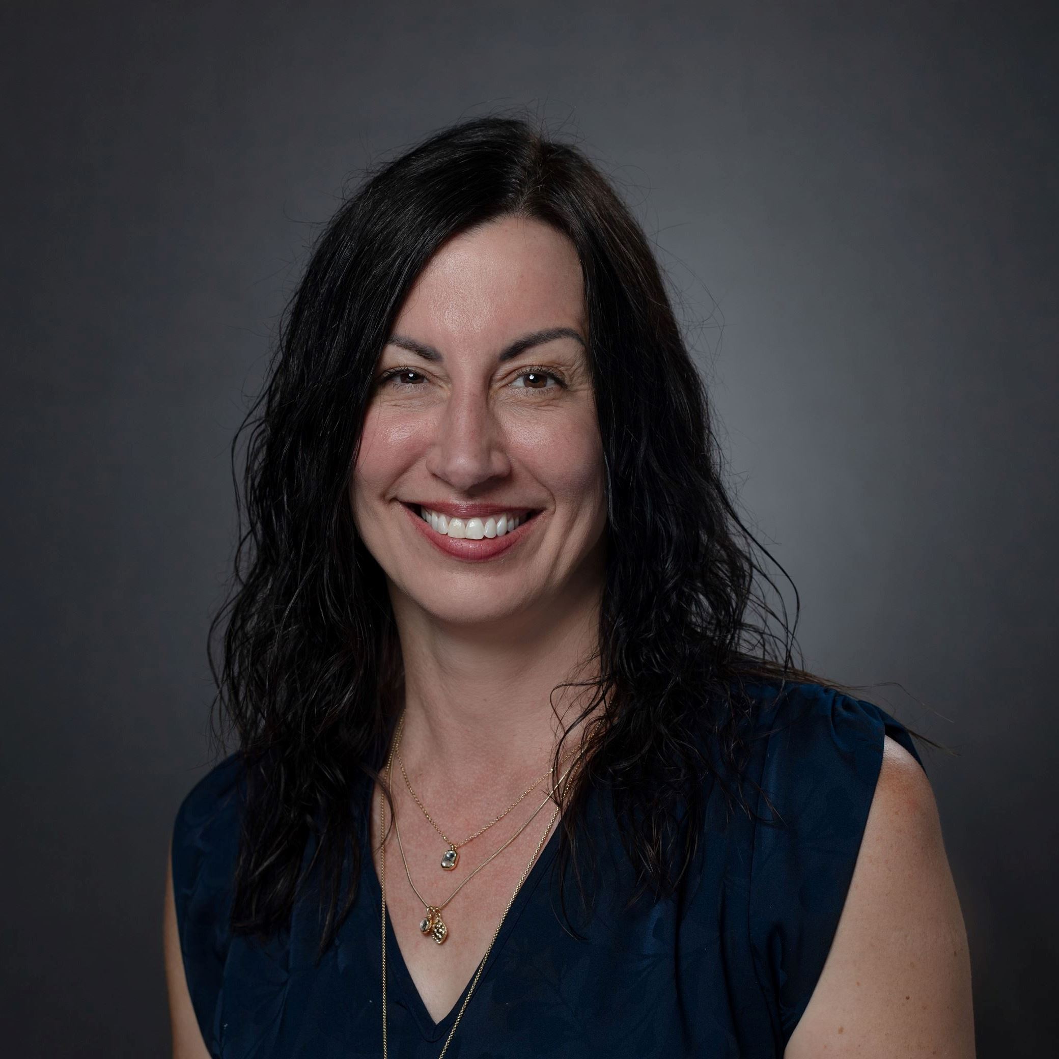 Headshots of Jenny Simpkins - female with long black hear wearing blue blouse 